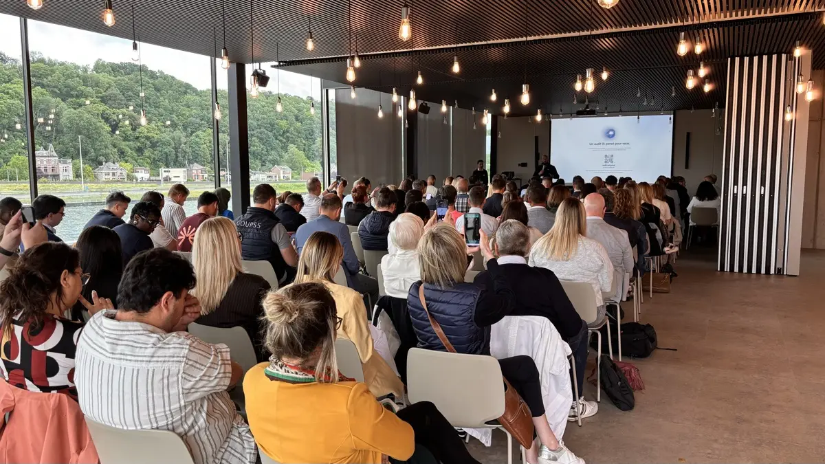 Conférence avec public au dernier étage, vue sur la Meuse